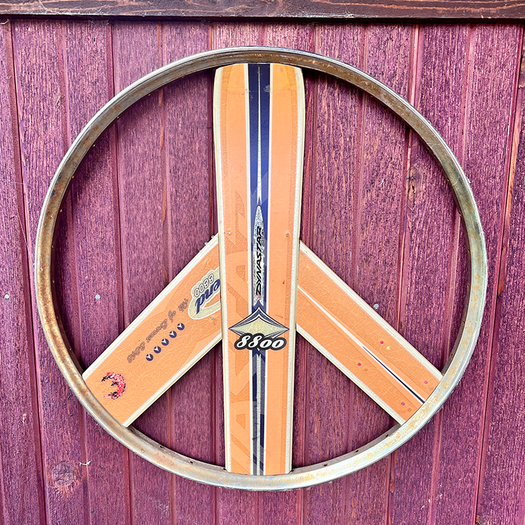 peace sign made with a bike rim and skis